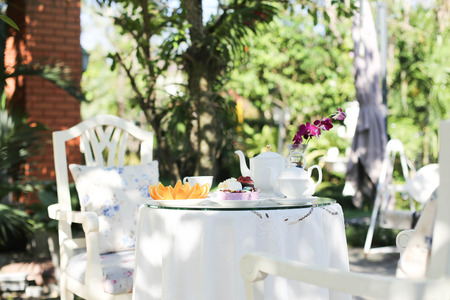 Afternoon tea and cakes and fruit orange in the gardenの写真素材