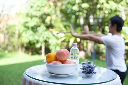 Man doing relaxation exercises Tai chi and healthy fruit and drinkの写真素材