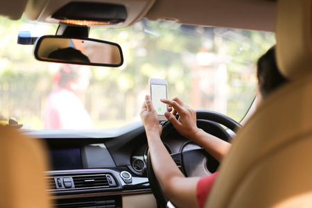 Concept - woman using phone while driving the car and hit a womenの写真素材