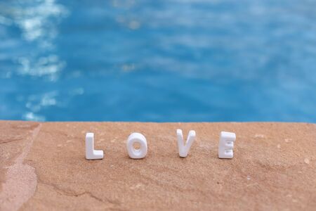 Word Love on the rocek and water on holiday background.の写真素材