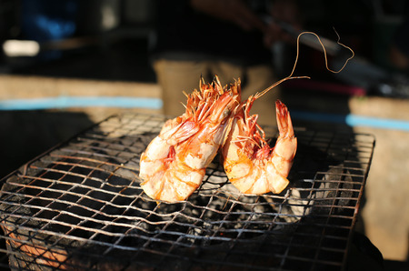 Grilled tiger prawns with charcoal in restaurantの写真素材