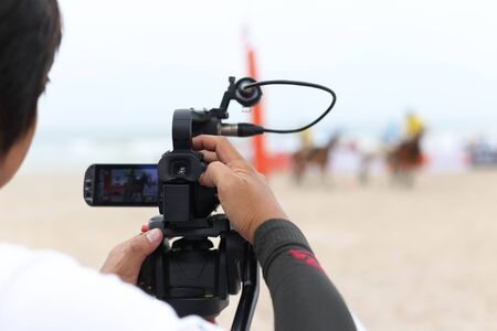 Man holding camcorder as working recording on a beach Polo Tournament sportの写真素材