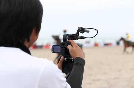 Man holding camcorder as working recording on a beach Polo Tournament sportの写真素材