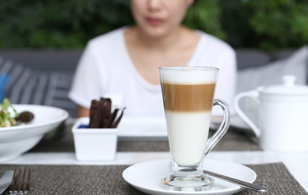 Asian woman having a coffee latte at lunch timeの写真素材