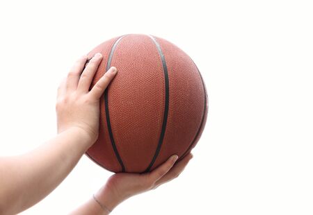 Childs Hand on basketball isolated on white backgroundの写真素材