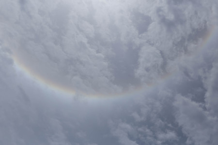 sun halo phenomenon with circular rainbow  in sky with cloudの写真素材