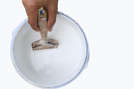Hand holding paint brush in to  paint tin in white backgroundの写真素材