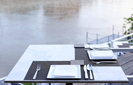 Dinner table set at riverside for dinner or eventの写真素材