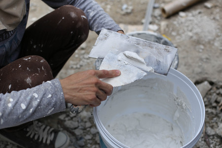 Plasterer mixing a plaster in bucket for renovation decorationの写真素材