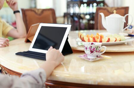 Business people having lunch and work with ipad tea and fresh fruit on the tableの写真素材