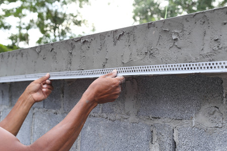 Asian man framing a wet concrete wall on construction siteの写真素材