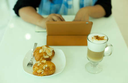 Selected Focus woman using computer tablet with coffee latte on the tableの写真素材