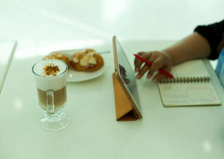 Selected Focus woman using computer tablet with coffee latte on the tableの写真素材