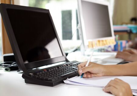 Education concept - student with computer doing homework at homeの写真素材
