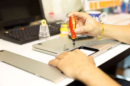 Male during repair his laptop using screw driverの写真素材