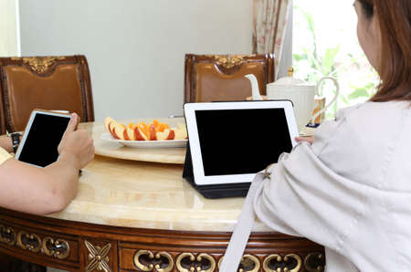 Business people having lunch and work with ipad tea and fresh fruit on the tableの写真素材