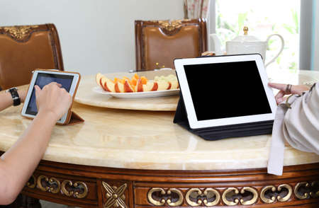 Business people having lunch and work with ipad tea and fresh fruit on the tableの写真素材