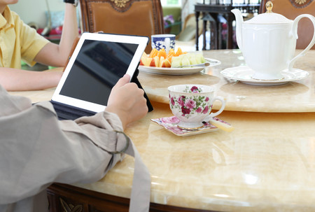 Business people having lunch and work with ipad tea and fresh fruit on the tableの写真素材