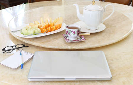 Business Concept Laptop computer with plate of fresh fruit and drinkの写真素材