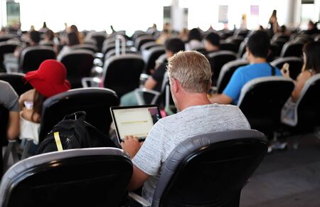 Man at the airport using his notebook computer while waiting for  the flightの写真素材