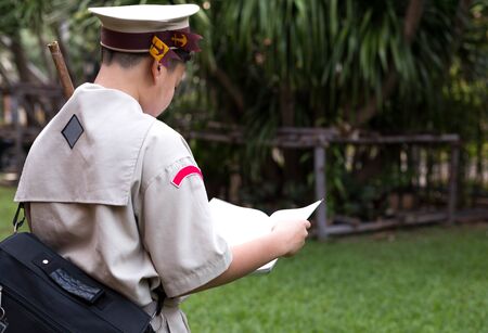 Unidentified asian scout in uniform looking to the bookのeditorial素材