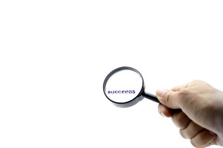 Business concept success letters under the magnifier in white backgroundの写真素材