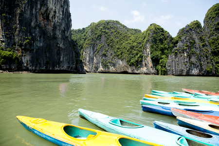 Colorful kayaks on the sea in Ha long bay Vietnam with tourist boatの写真素材