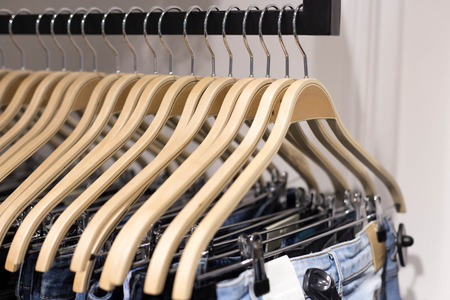 Wooden clothes hang on a shelf in a clothes storeの写真素材
