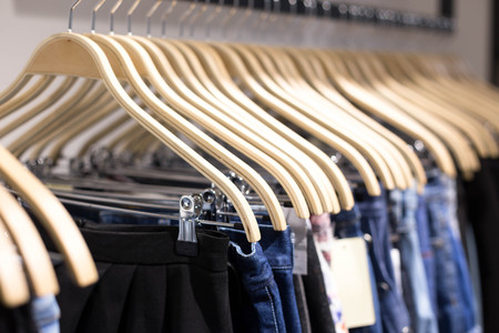 Wooden clothes hang on a shelf in a clothes store