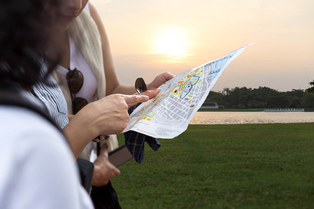 Traveler of  woman looking at the map for right direction in sunset