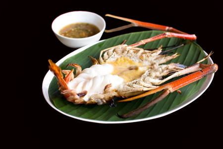 Grilled fresh King prawn with spicy sauce isolated in black backgroundの写真素材