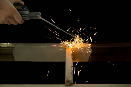 Man welding steel in construction site isolated in black background