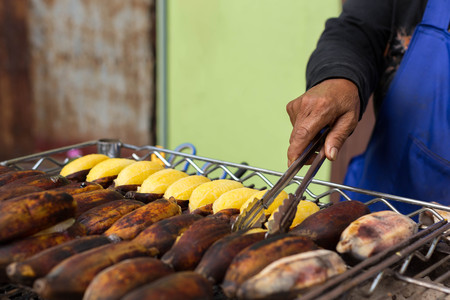 Asian woman grilled banana sale in the market in Thailandの写真素材