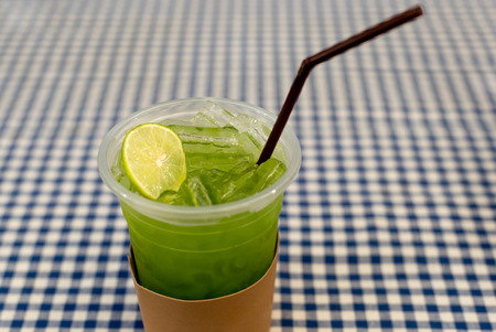Healthy green fresh juice with ice made from kiwi fruit on tableの写真素材