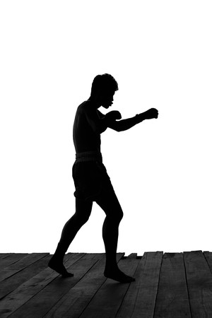 Man exercising Thai boxing in silhouette isolated in white backgroundの写真素材