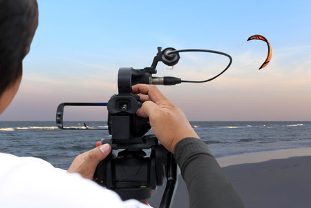 Man recording a kite surfer on the beach  in Thailandの写真素材