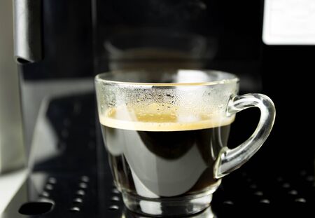 Cup of black coffee on coffee machine makerの写真素材