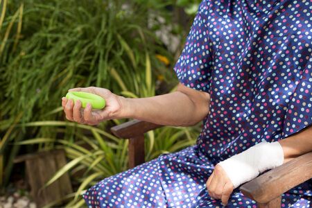 Senior woman doing hand exercise with green circle workout equipment for Physical Therapy patient isolatedの写真素材