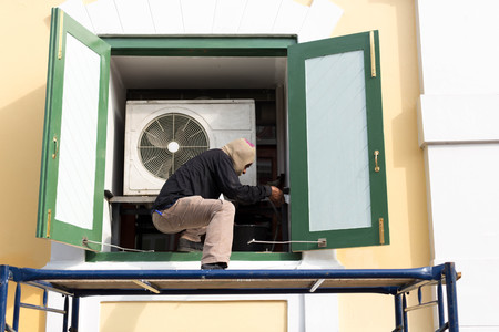Unidentified man working on Painting window on the building with scaffoldの写真素材