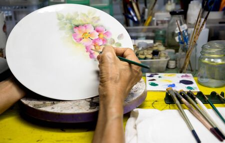 woman hand painting ceramic plateの写真素材