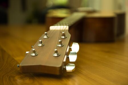 Headstock of acoustic guitar on wooden tableの写真素材