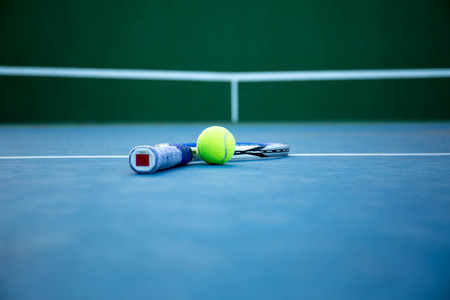 Tennis ball and racket on tennis court with white lineの写真素材