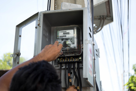 Electrician engineer repairing fuse box with screwdriver on electric boxの写真素材