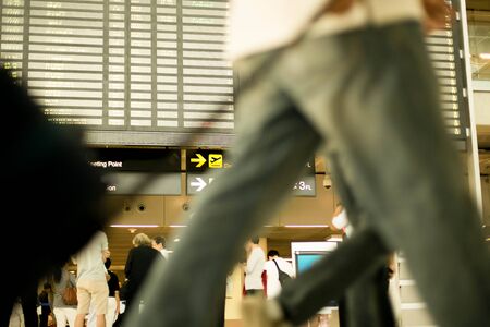 Time table board at the airport with businessman with a briefcase in blurred motion
