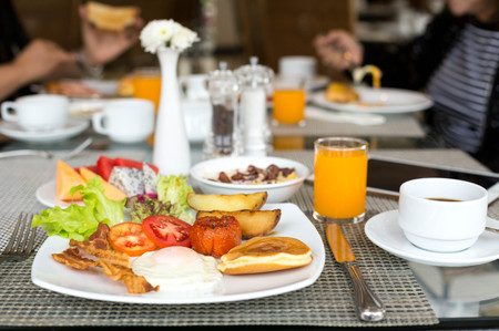 Breakfast set on the table with pancakes, bacon, eggs and coffeeの写真素材