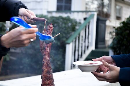 Man brushing sauce on barbecue spare ribs in winter timeの写真素材