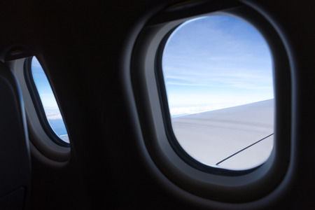 View of cloud with blue sky from airplane window in the morning