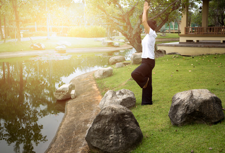 Asian woman doing yoga in morning in the park in the morningの写真素材