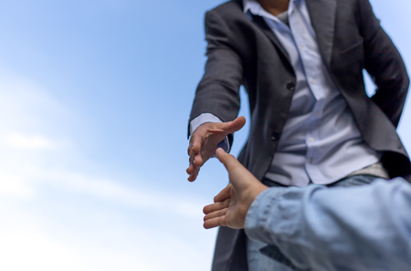 Help concept hand reaching out to help someone with blue sky  backgroundの写真素材