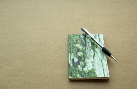 Notebook and pen on  brown paper background